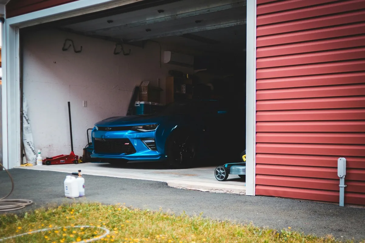 Car parked inside an open two-car garage