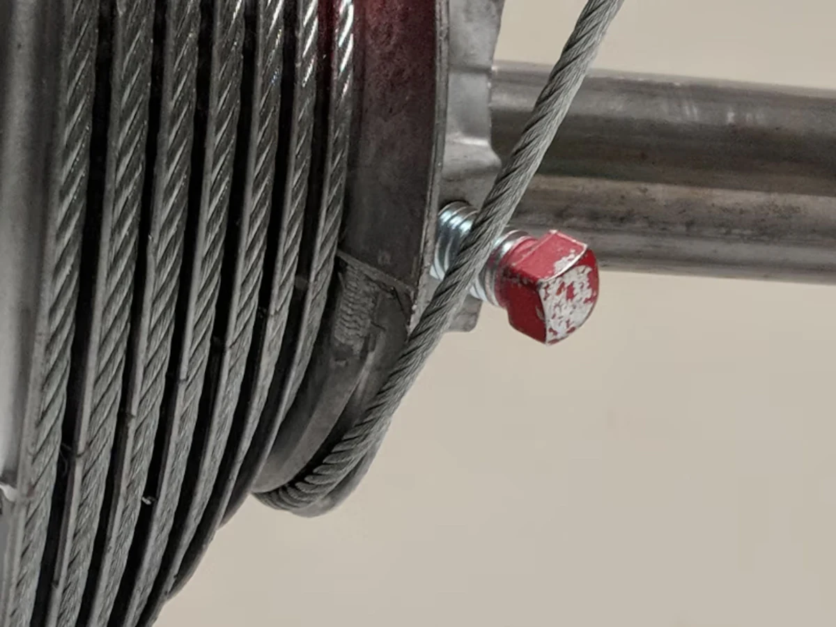 Close-up of a garage door cable wound on its drum
